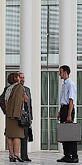 Image de trois personnes devant un bâtiment public